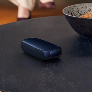 Ploom X Advanced navy blue s koženým zadným krytom na stole