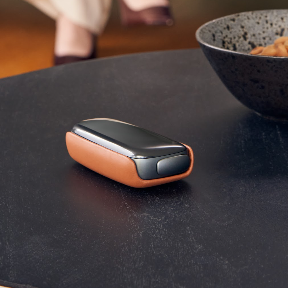 Čierný Ploom X Advanced v hnedom koženom krytu na stole